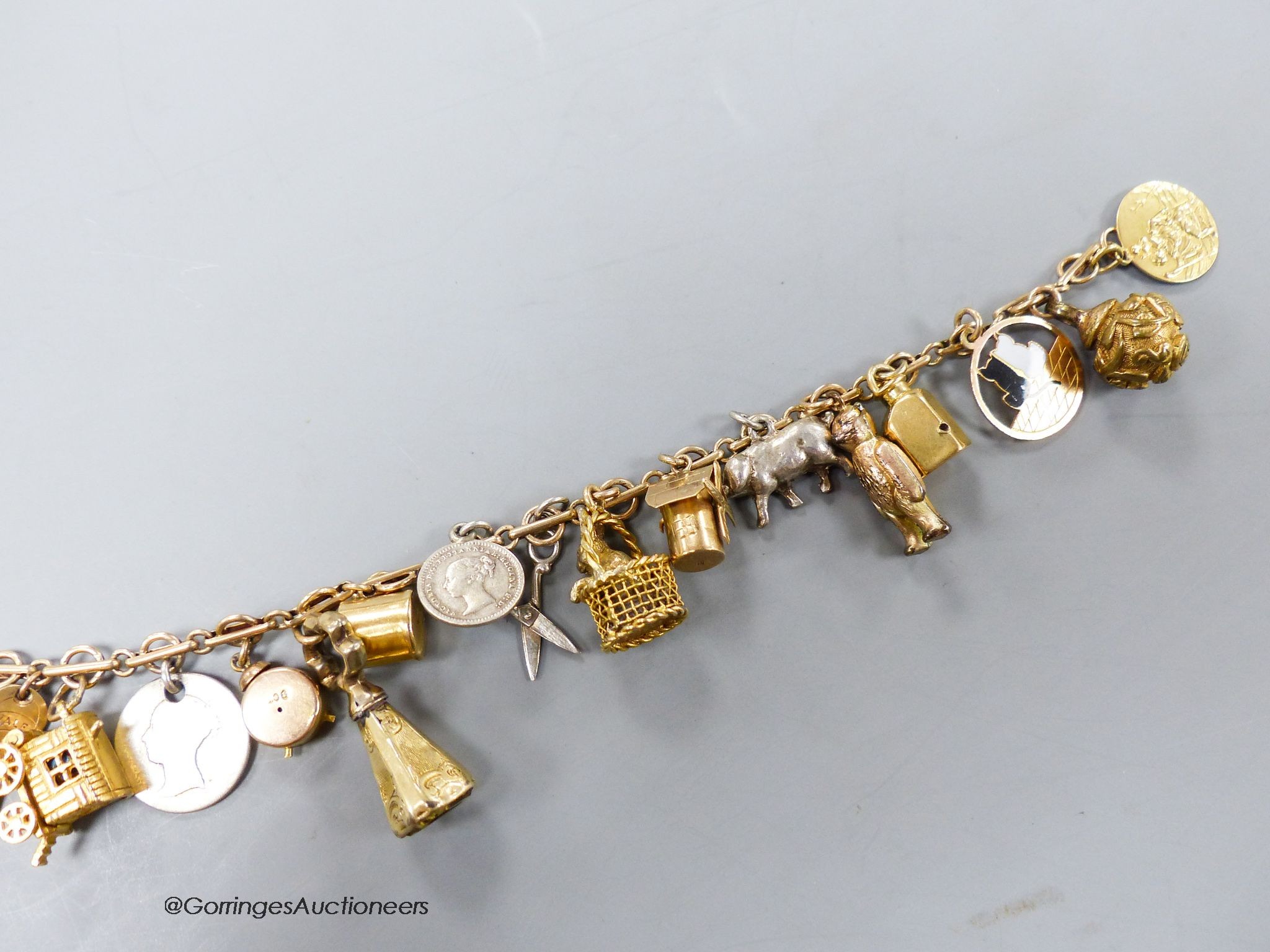 A 9c charm bracelet, hung with nineteen assorted charms, gross 38 grams.
